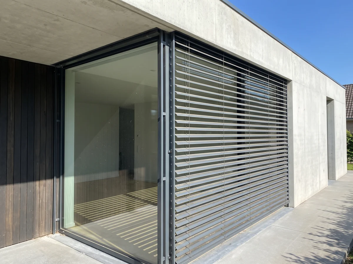 Stores extérieurs de façade à lames aluminium sur une fenêtre moderne